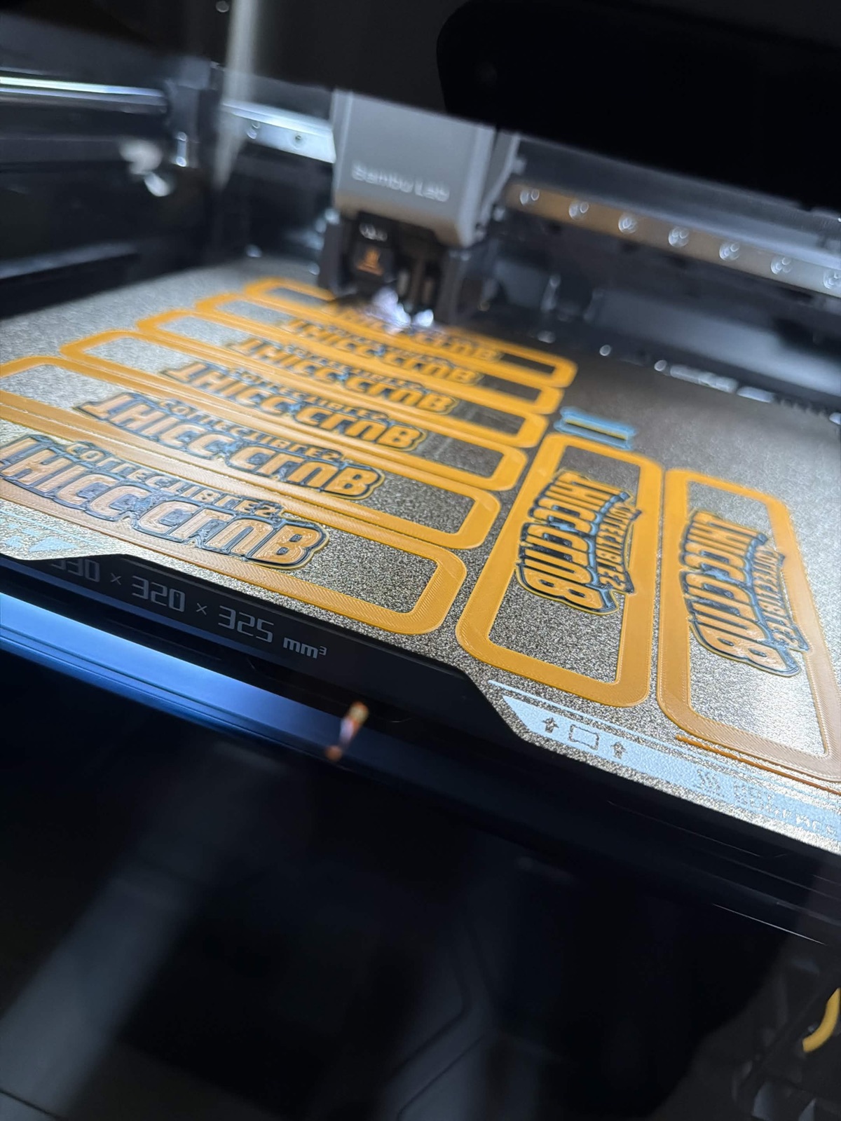 3D printer mid-print producing multiple riser nameplates
