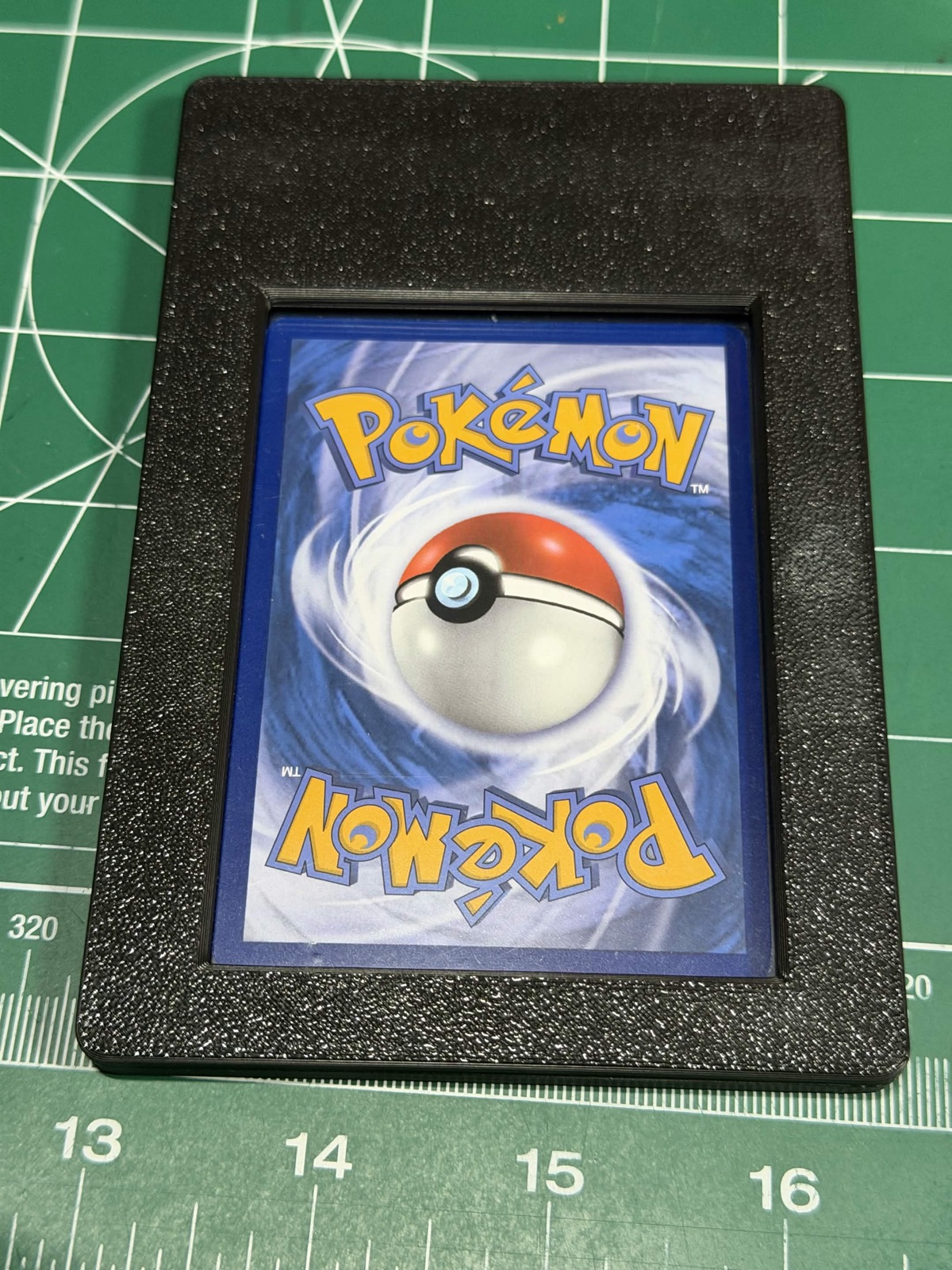 Back of a graded Pokemon card slab seated in a Thicc Club Prints riser
